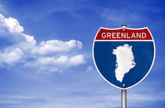 A highway sign with an outline of Greenland, symbolizing the geopolitical pressure from the U.S. and its impact on international news and relations.