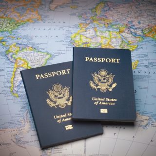 Brown leather travel bag with passport and boarding pass at airport check-in counter showing international travel and global mobility for expats planning relocation