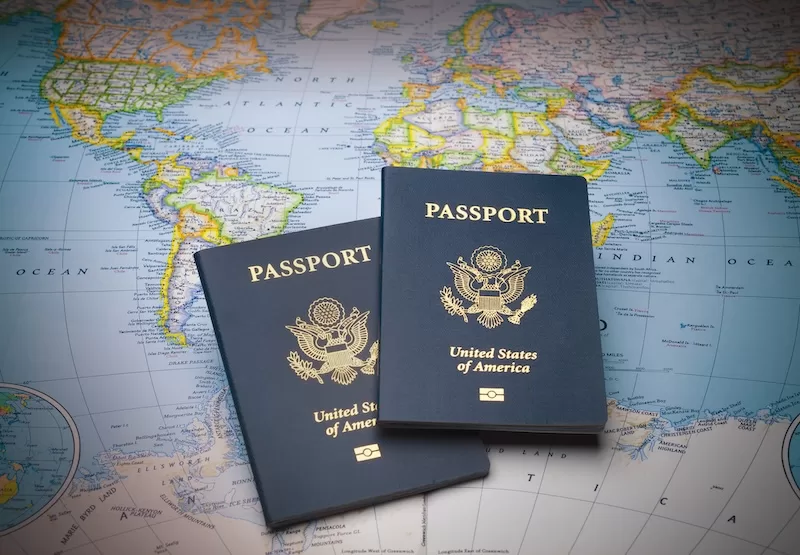 Brown leather travel bag with passport and boarding pass at airport check-in counter showing international travel and global mobility for expats planning relocation