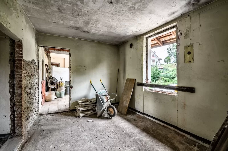The interior of a derelict house with crumbling walls and debris, showing the extensive renovation work required for Italy's widely publicized €1 homes.