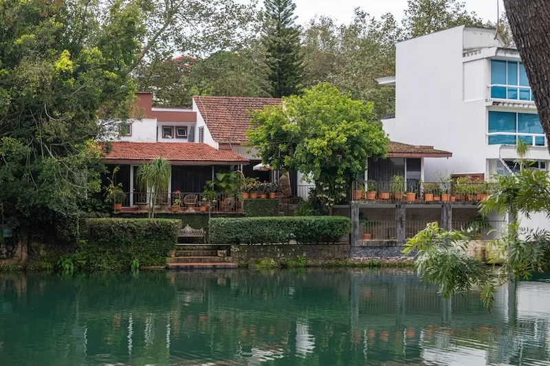 A tranquil view of a lakeside home in Xalapa, surrounded by lush greenery, highlighting the affordable and peaceful lifestyle available to expats.