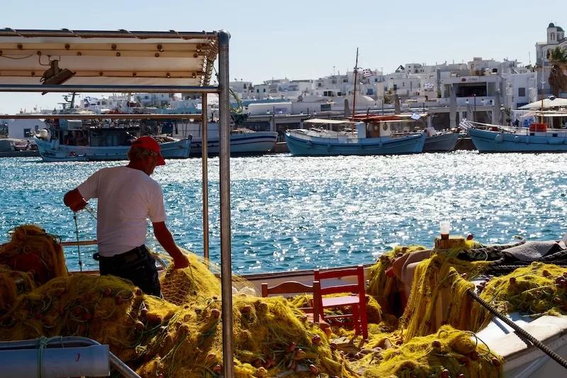 Greek fishing village with white buildings and traditional boats showing secondary city charm and livability for global relocators