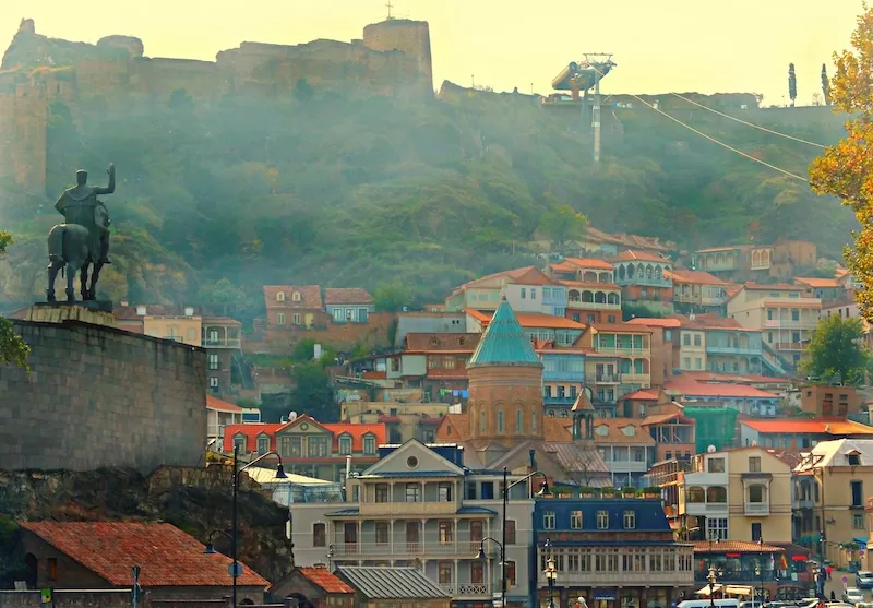 Tbilisi cityscape with historic fortress and colorful buildings showing Georgia's appeal as digital nomad haven with affordable living and emerging residency programs