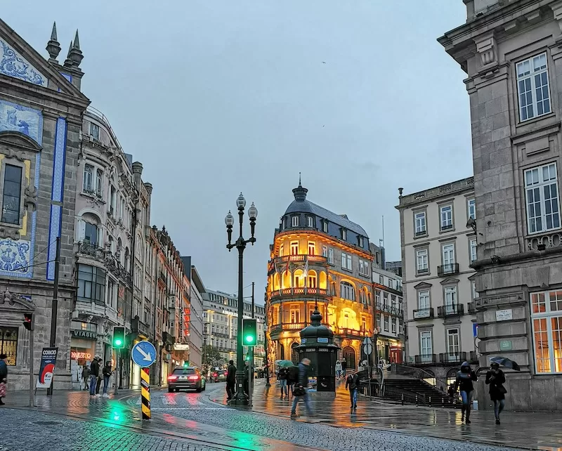 Rainy Porto street with grey granite and café scene showing the city's Atlantic climate and cozy indoor culture that expats learn to appreciate and embrace