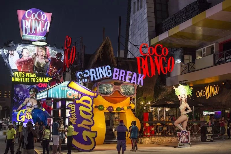 Colorful neon signs for Coco Bongo nightclub and Spring Break entertainment venue illuminated at night in a vibrant entertainment district area view