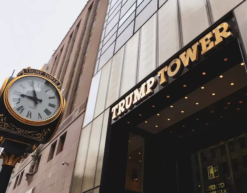 Trump Tower storefront with golden lettering and an ornate clock on the building facade in an urban commercial downtown area in the city center view