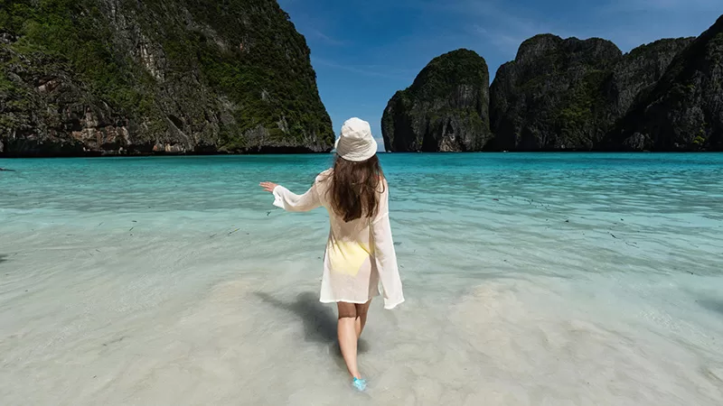 Woman wading in shallow water with karst formations