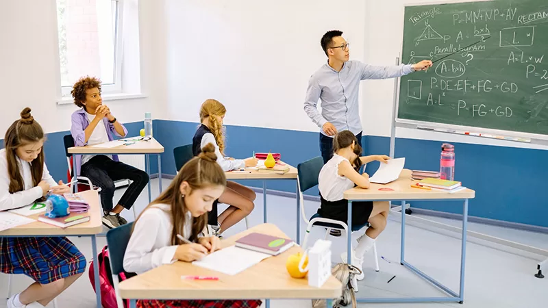 A teacher leads a classroom of engaged students.