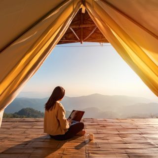 Remote worker with laptop and tablet at outdoor garden desk showing digital nomad lifestyle and location independence for global professionals seeking residency