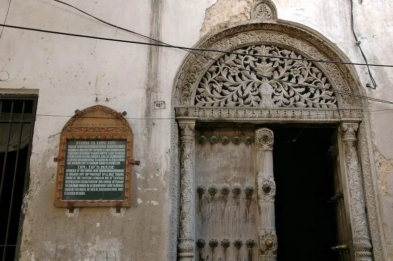 A close-up of the intricately carved wooden door at Tippu Tip’s former house in Stone Town, a significant landmark of Zanzibar’s complex trading history.