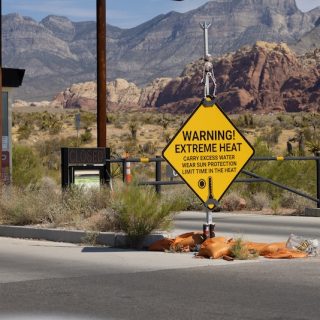 extreme heat warning sign in desert landscape western United States climate crisis