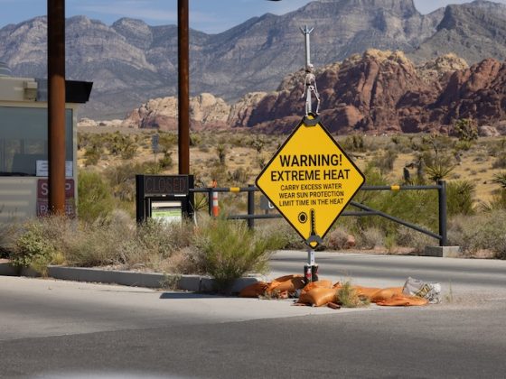 extreme heat warning sign in desert landscape western United States climate crisis