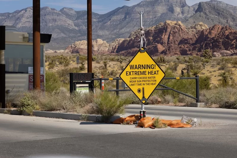 extreme heat warning sign in desert landscape western United States climate crisis