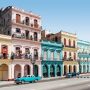 Colorful colonial buildings and classic cars lining a historic street in Havana, Cuba.