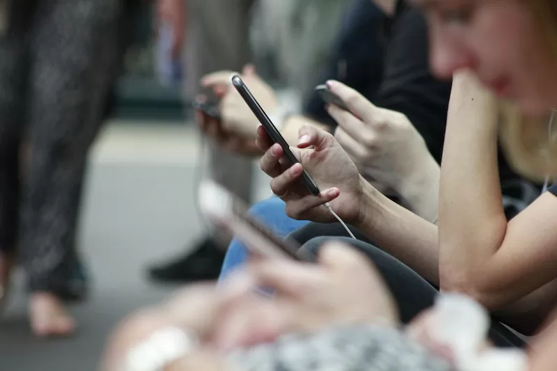 People using smartphones highlighting concerns over social media addiction and digital behavior