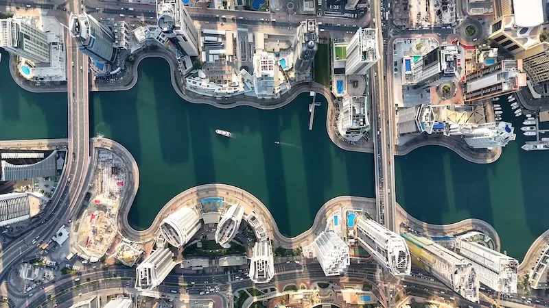 Top-down aerial view of Dubai Marina canals surrounded by high-rise residential towers and city roads.