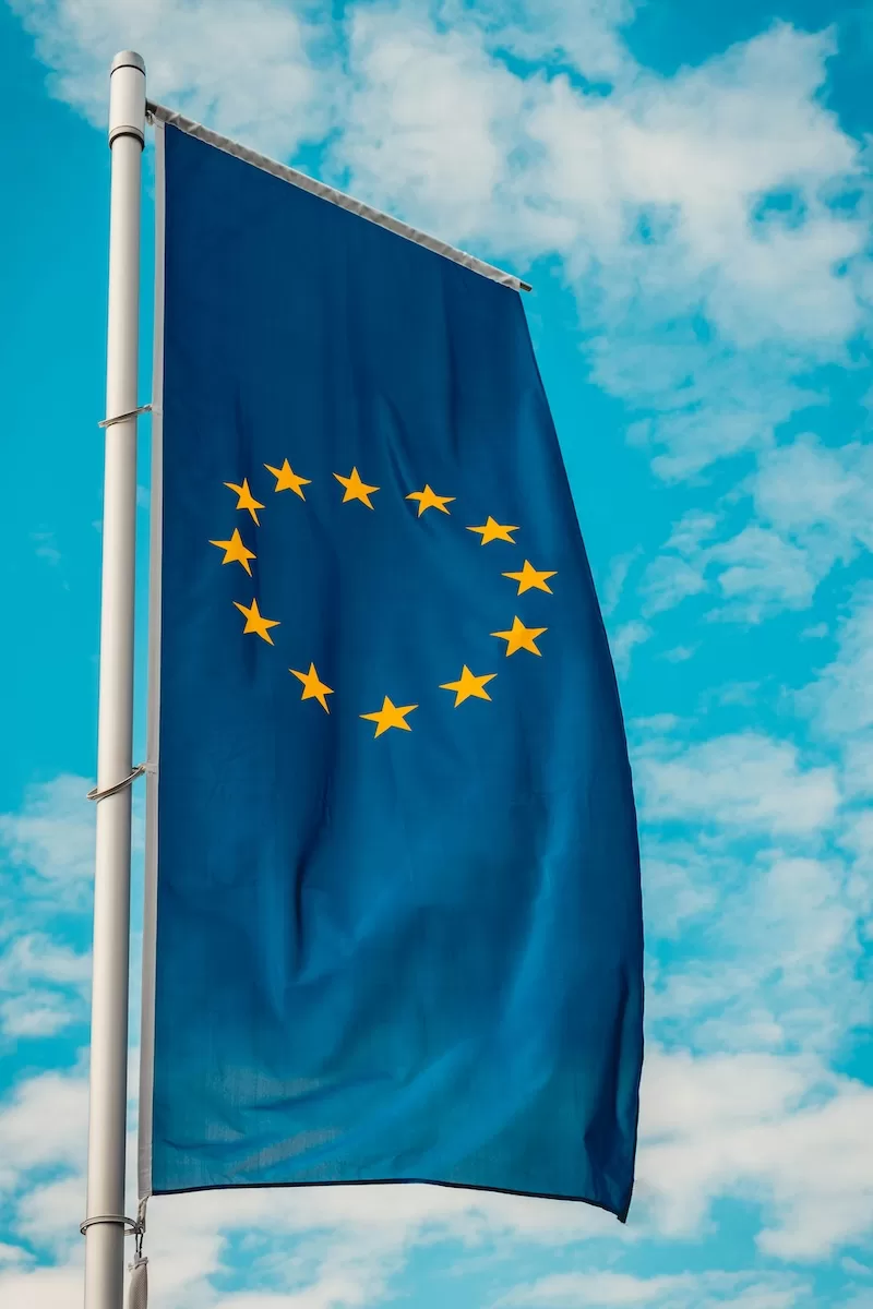 European Union flag waving against blue sky representing EU residency and mobility opportunities