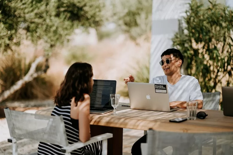 Remote workers using laptops outdoors in a relaxed setting representing digital nomad lifestyle in Europe