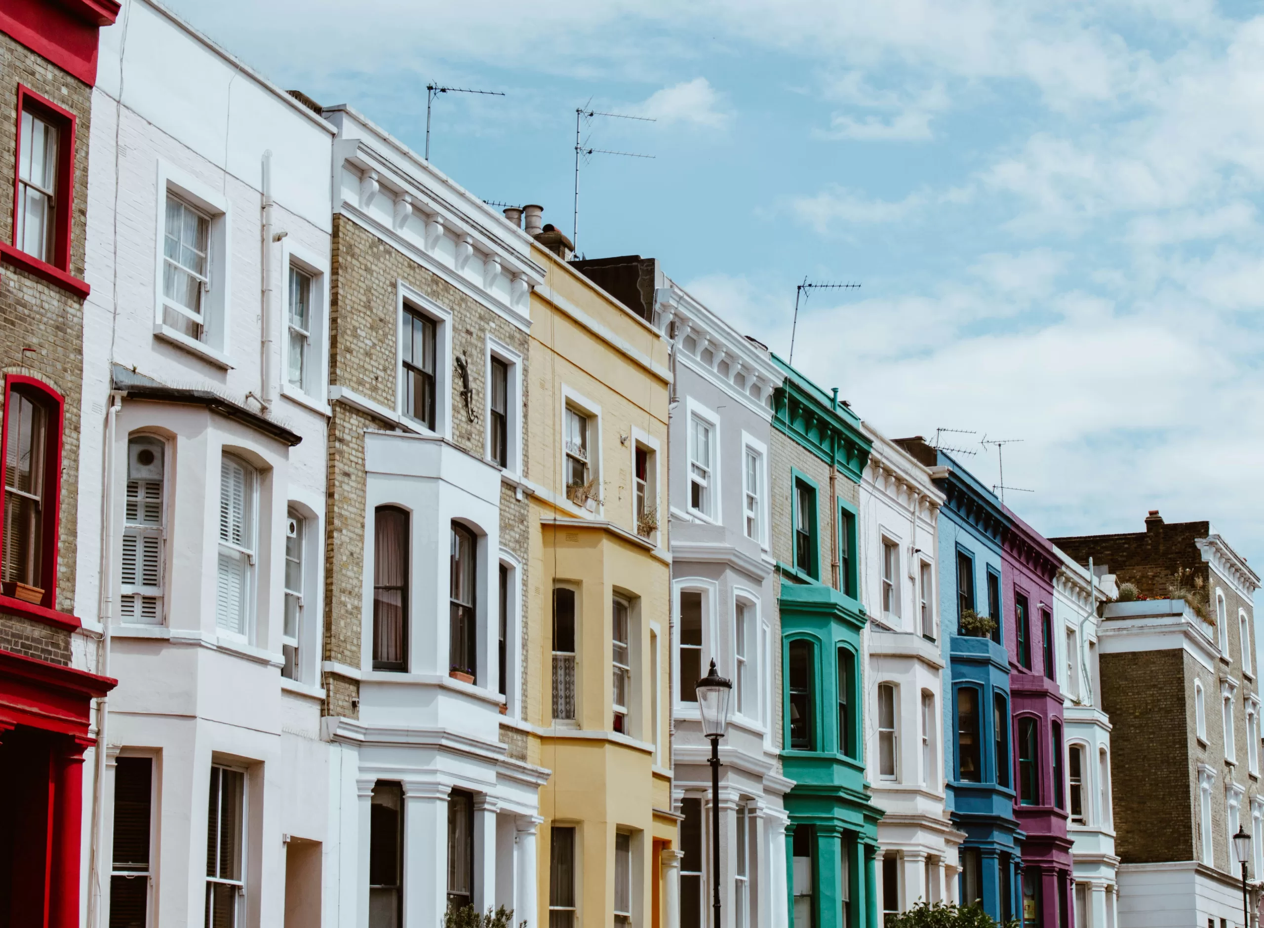 Colorful European townhouses along a quiet residential street with pastel facades