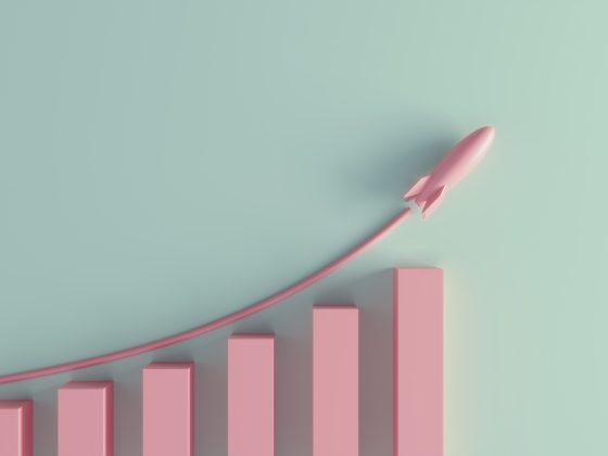 Rocket launching upward above a rising bar chart representing business growth