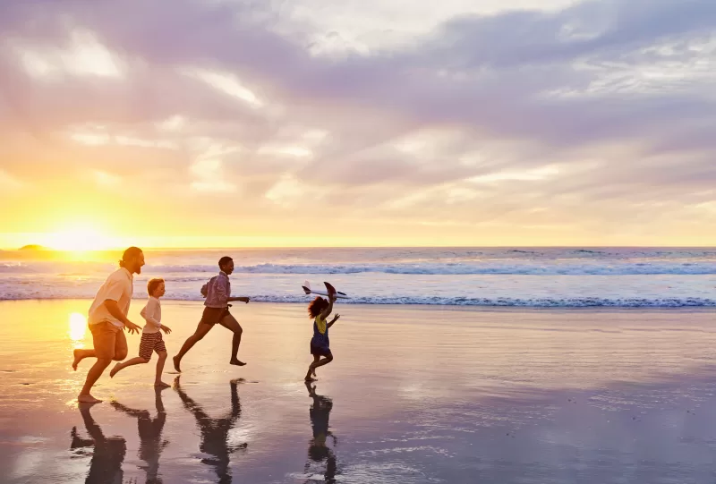 Family of four walking along the beach, representing family-driven approach to starting over abroad