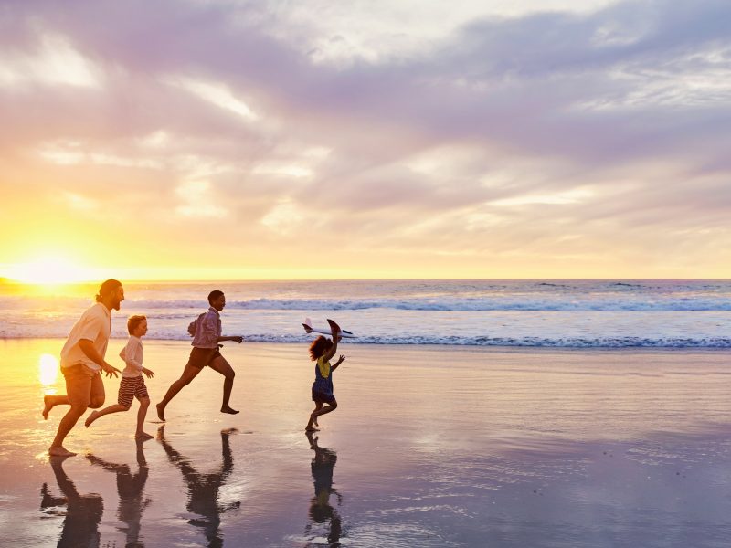 Family of four walking along the beach, representing family-driven approach to starting over abroad