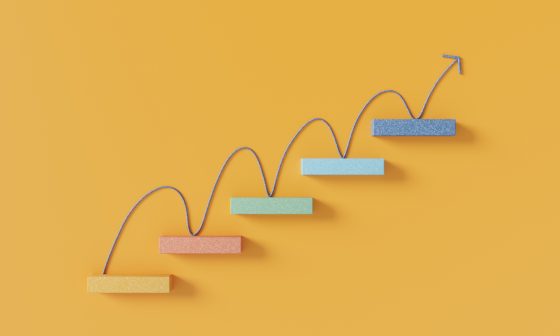 Upward arrow moving across rising steps representing growth and progress.