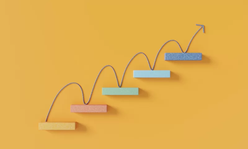 Upward arrow moving across rising steps representing growth and progress.