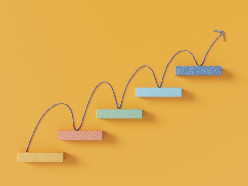 Upward arrow moving across rising steps representing growth and progress.