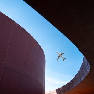 Overlooking modern red three-dimensional buildings and flying planes, taken in the Library Park of Quanzhou City, Fujian Province, China