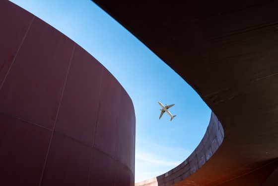 Overlooking modern red three-dimensional buildings and flying planes, taken in the Library Park of Quanzhou City, Fujian Province, China