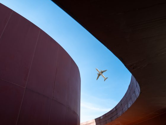 Overlooking modern red three-dimensional buildings and flying planes, taken in the Library Park of Quanzhou City, Fujian Province, China