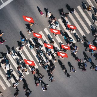 People crossing a street with social media icons symbolizing widespread digital engagement