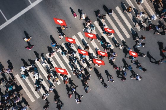 People crossing a street with social media icons symbolizing widespread digital engagement