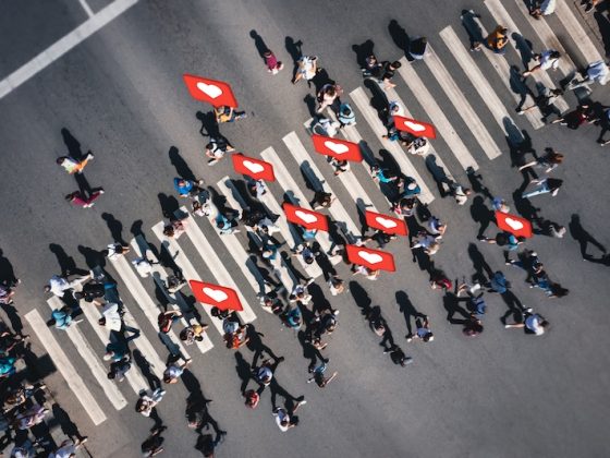 People crossing a street with social media icons symbolizing widespread digital engagement