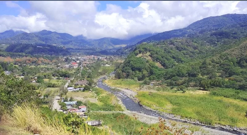 River valley and green mountain landscape in Panama’s Boquete region under a bright sky.