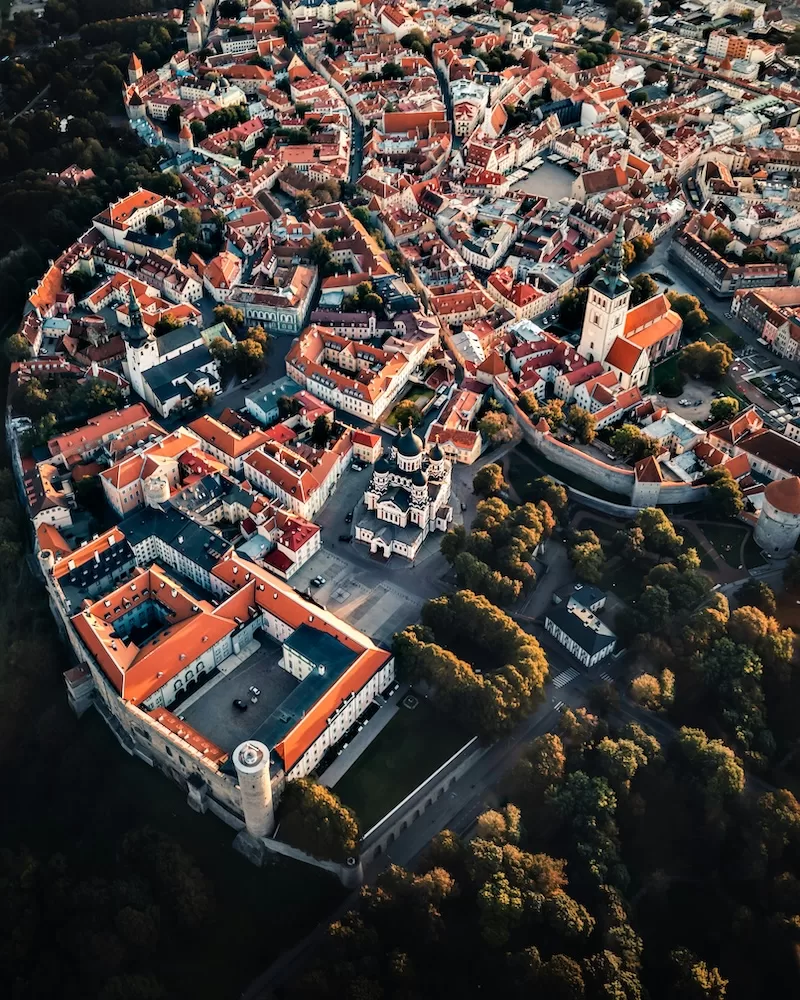 Aerial view of Tallinn’s historic old town with red rooftops, church spires, and fortified walls.