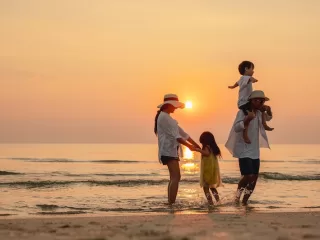 Happy asian family that enjoys beach activities during the summer holidays. parent and children enjoy the sunset sea on beach.Holiday travel concept, Summer vacations.