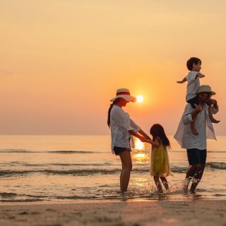Happy asian family that enjoys beach activities during the summer holidays. parent and children enjoy the sunset sea on beach.Holiday travel concept, Summer vacations.