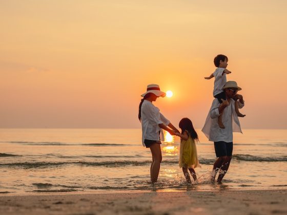 Happy asian family that enjoys beach activities during the summer holidays. parent and children enjoy the sunset sea on beach.Holiday travel concept, Summer vacations.