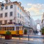 Yellow Lisbon tram passing through a historic street near Rua Augusta Arch.