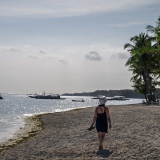 Woman walking along a quiet beach in the Philippines