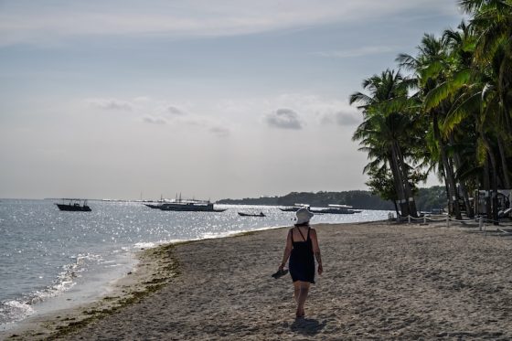 Woman walking along a quiet beach in the Philippines