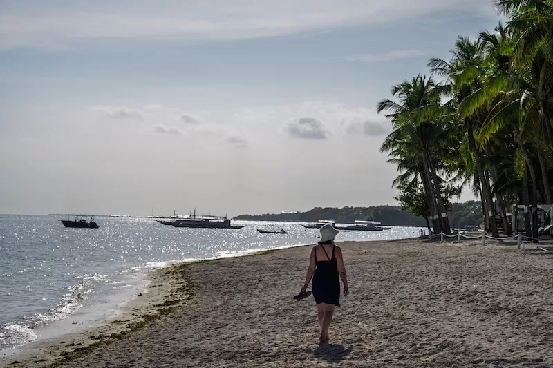 Woman walking along a quiet beach in the Philippines