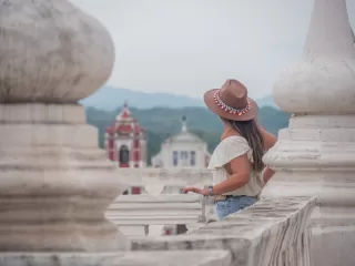 Traveler overlooking a historic Nicaraguan city from a terrace framed by white columns