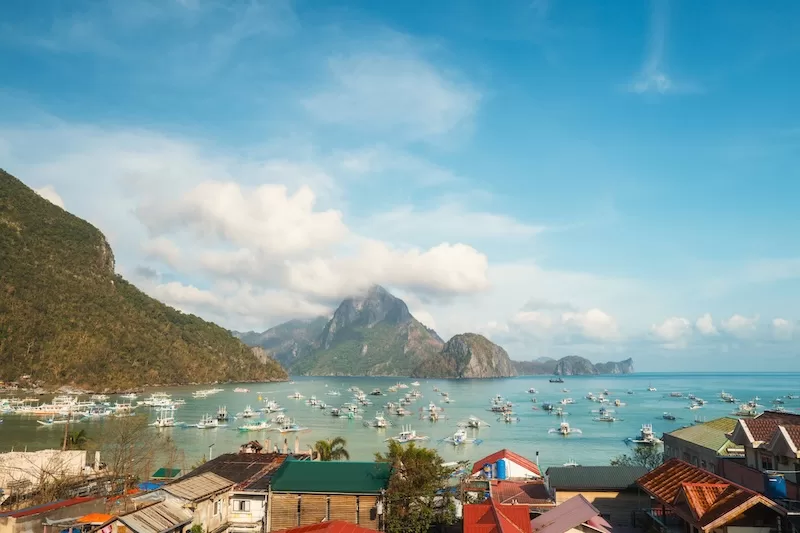 Boats in a scenic Philippine bay surrounded by limestone cliffs