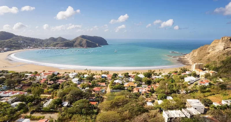 Aerial view of San Juan del Sur on Nicaragua’s Pacific coast with crescent beach and hillside homes