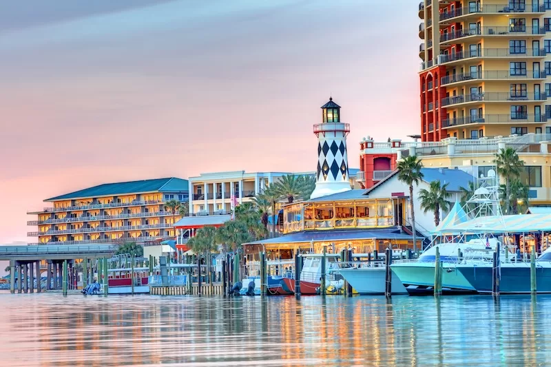 Waterfront resort and marina in Florida with boats, palm trees, and a lighthouse-style building