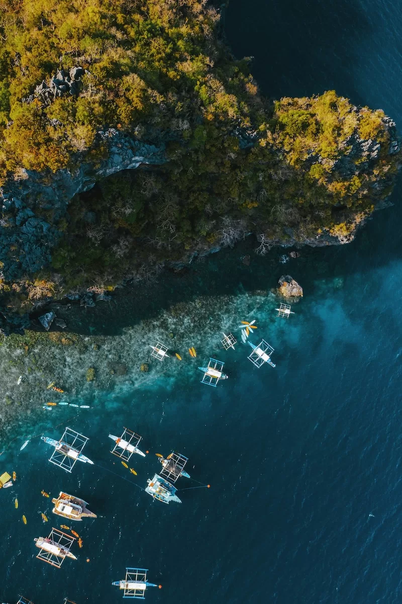 Aerial view of boats near a tropical island coastline in the Philippines