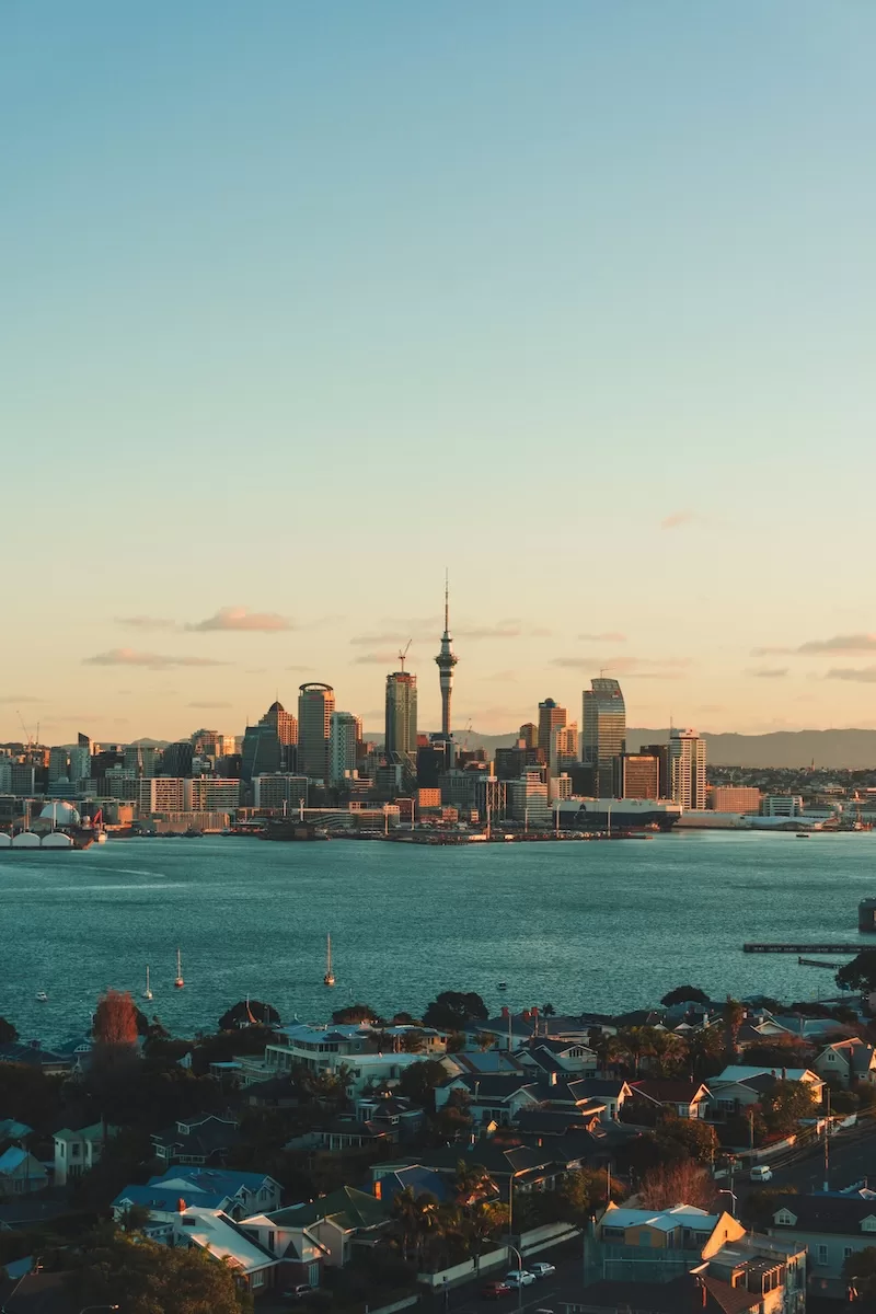 Auckland skyline viewed across the harbor at sunset in New Zealand